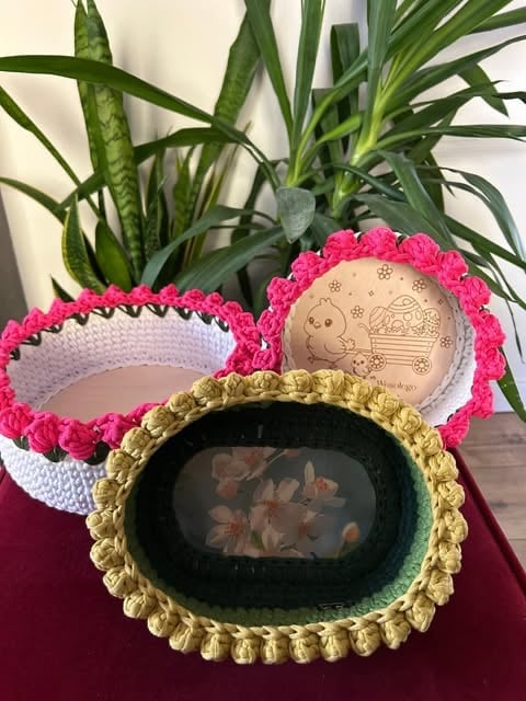 Trzy ręcznie zrobione miseczki szydełkowane z falbankami w kolorach różowym, białym i żółto-zielonym