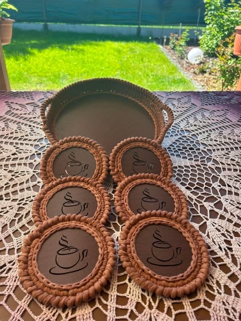 Six chocolate tarts with coffee cup designs arranged in front of a serving basket on an outdoor patio table