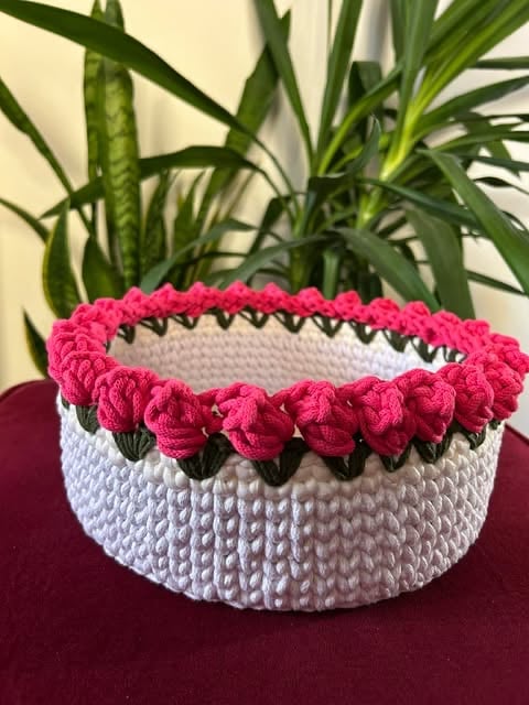 Biały koszyczek szydełkowany z różowym pomponowym brzegiem